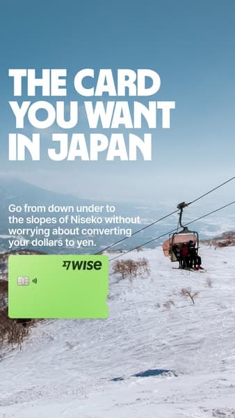 Advertising banner with a snowy ski slope and chairlift in the background, large white text reading "THE CARD YOU WANT IN JAPAN," smaller text below saying "Go from down under to the slopes of Niseko without worrying about converting your dollars to yen," and a green Wise card image; no visible CTA.