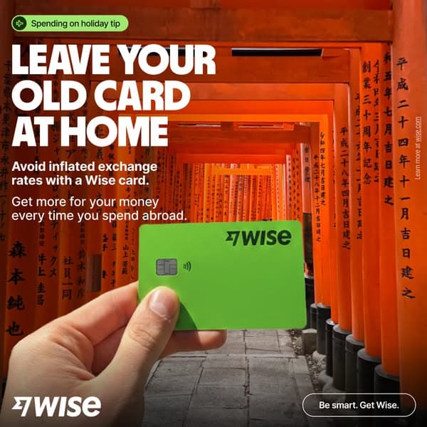A hand holds a bright green Wise card against a background of orange torii gates, with the headline "LEAVE YOUR OLD CARD AT HOME" and supporting text "Avoid inflated exchange rates with a Wise card. Get more for your money every time you spend abroad," plus the call-to-action button "Be smart. Get Wise.