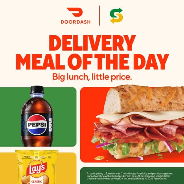 DoorDash advertising banner with a beige background featuring the headline "Delivery Meal of the Day" and subtext "Big lunch, little price." Images show a sub sandwich with various deli meats and cheese, a bottle of Pepsi Zero, and a bag of Lay's Classic chips.