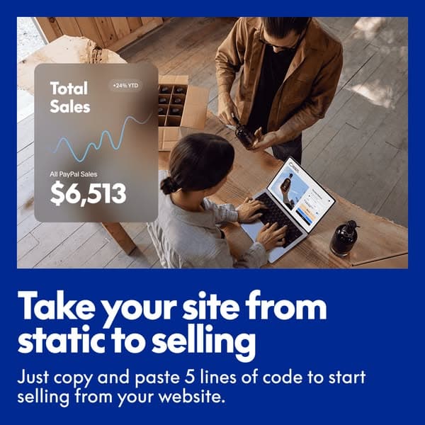 A top-down view of two people working at a wooden table with a laptop and product, overlaid with a sales graph reading "Total Sales +24% YTD All PayPal Sales $6,513," and bold white text on a blue background stating "Take your site from static to selling" with smaller text "Just copy and paste 5 lines of code to start…
