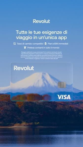 A vertical banner with a blue sky background, showing a transparent Revolut Visa card over a scenic mountain and lake view, featuring the text: "Tutte le tue esigenze di viaggio in un'unica app" and icons for competitive exchange rates, immediate eSIM plans, and worldwide cash withdrawal.