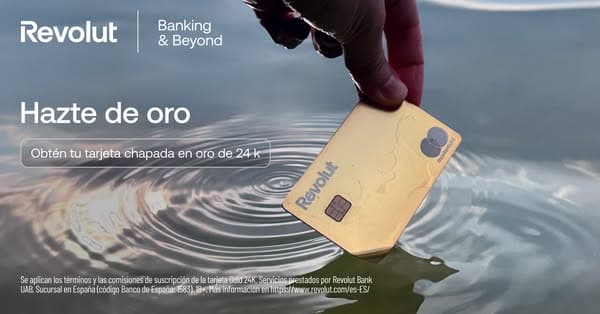 Advertising banner for Revolut on a blue-gray water ripple background showing a hand holding a shiny gold card, with text "Hazte de oro" and "Obtén tu tarjeta chapada en oro de 24 k", along with the Revolut logo and "Banking & Beyond" tagline.